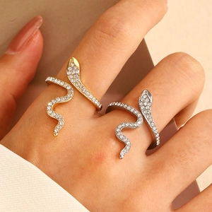 Detailed close-up of snake-shaped rings with sparkling zircons in gold and silver finish