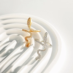 Detail shot of gold and silver snake rings with cubic zirconia on white wave steps