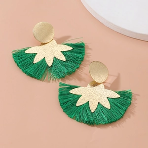 Orecchini a fiore d'oro boho con nappine in seta verde vibrante su sfondo pesca chiaro