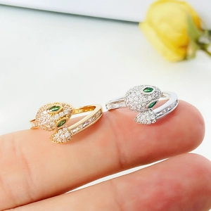 Detail of snake ring set with sparkling zircon micro-paving and emerald green gem eyes
