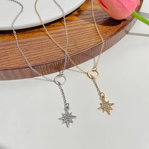 Detail view of multi-layered gold and silver star pendants with sparkling zircons