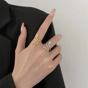 Detail of snake wrap rings in gold and silver finish with micro-paved sparkling zircon stones