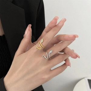 Close-up of gold and silver snake rings with shimmering pavé zircon stones on hand