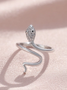 Macro shot of silver snake ring with micro-paved cubic zirconia on pink satin fabric