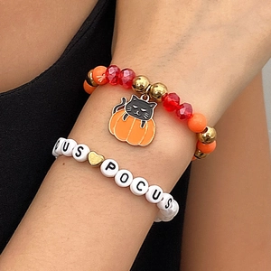 Detalle de pulseras de Halloween con cuentas de letras Hocus Pocus y colgante de calabaza