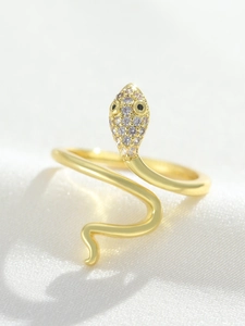 Macro shot of gold-plated snake ring featuring micro-paved zircons on white silk