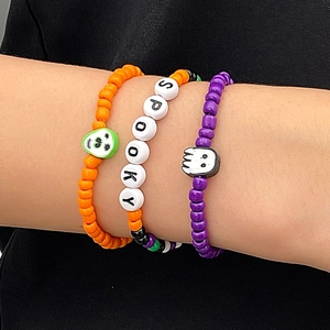 Detalle de pulseras de cuentas de Halloween con letras SPOOKY y dijes de fantasmas