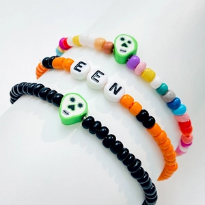 Detalle del set de pulseras de Halloween con dijes de calavera y cuentas de letras