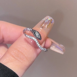 Macro shot of silver snake ring with micro-pave white crystals and black head detail