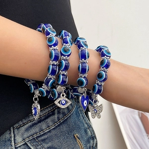 Set de cuatro pulseras de cuentas azules Evil Eye con dijes de mariposa y corazón