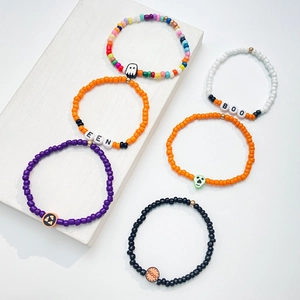 Vista detallada de pulseras de cuentas de Halloween con dijes de fantasma y calabaza