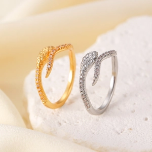 Macro shot of gold and silver snake rings with cubic zirconia pavé on stone