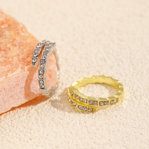 Macro shot of gold and silver wrap rings featuring a segmented snake design with cubic zirconia