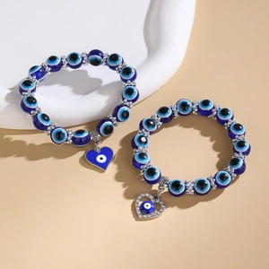 Primer plano de pulseras de cuentas azules del mal de ojo con colgantes de corazón y joyas