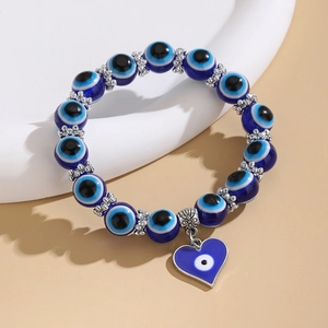 Detalle macro de pulsera Ojo Turco con colgante de corazón azul y cuentas de plata