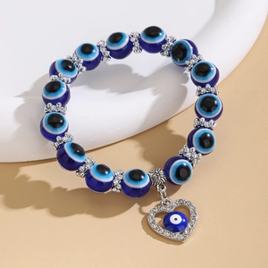 Detalle de pulsera de cuentas de ojo turco azul con espaciadores de plata y dije de corazón