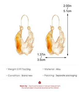 Detail view of large gold-tone drop earrings with textured lava design and dimensions