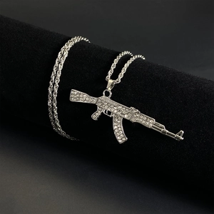 Macro shot of silver AK-47 pendant with iced-out crystals and a rope chain strap