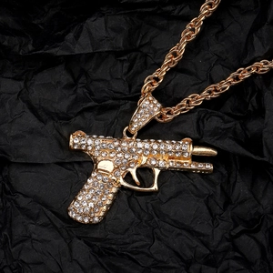 Macro shot of hip hop AK rifle pendant with gold plating and sparkling rhinestones