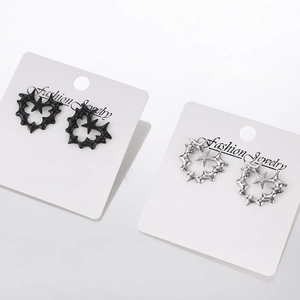 Macro shot of gothic thorn heart earrings with pentagram star in matte black and silver