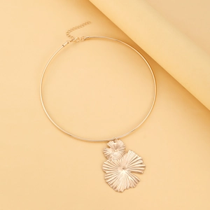 Detailed view of golden choker necklace featuring petal pendants with radial textures and chain