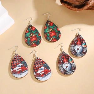 Three pairs of wooden teardrop Christmas earrings featuring Santa and holiday patterns