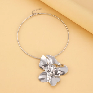 Detail of silver choker with abstract liquid metal floral pendant on orange backdrop