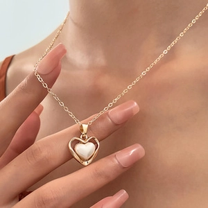 Detailansicht einer goldenen Herz-Halskette mit eleganter Perleneinlage an einer feinen Kette