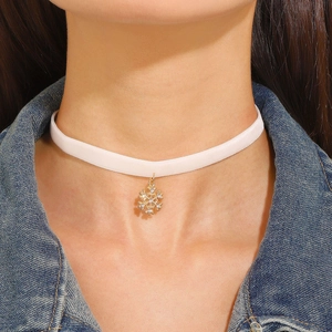 Close-up of pink velvet choker with a gold snowflake pendant and inlaid rhinestones
