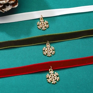 Close-up of snowflake pendant velvet chokers in white, green, and red festive colors