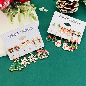 Weihnachtliche Ohrring-Sets mit Weihnachtsmann- und Rentier-Motiven auf festlichem Hintergrund