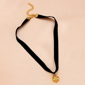 Detail of black velvet choker with gold floral pendant and adjustable metal clasp