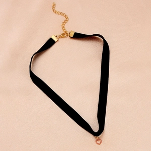Close-up of black velvet choker with heart pendant and gold lobster clasp adjustment