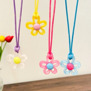 Detail bunter Blumenanhänger an gewebten Kordeln in Gelb, Lila, Rosa und Blau