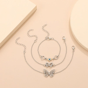 Three-piece silver butterfly anklet set with rhinestone charms and evil eye beads