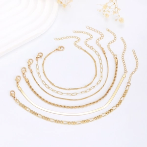 Détail d'un ensemble de 6 bracelets chaîne dorés incluant les styles figaro et serpent