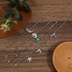 Vue détaillée de colliers argentés avec pendentifs western sur un fond en bois rustique
