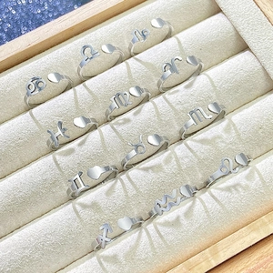 Collection of twelve zodiac rings with heart charms in a beige velvet jewelry box