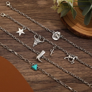 Gros plan de bracelets bohèmes en argent avec des breloques comme des étoiles et crânes