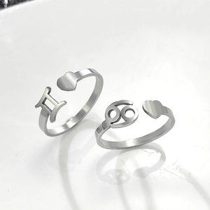 Detail of adjustable silver Gemini and Cancer zodiac rings with heart accent