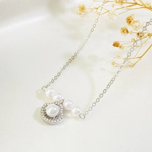 Elegant silver shell pendant necklace with pearls and rhinestones on white silk