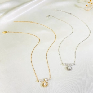 Detail showing gold and silver shell pendants with freshwater pearls and sparkling crystals