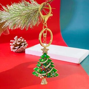 Detailed view of a green Christmas tree keychain with colorful rhinestones and gold plating