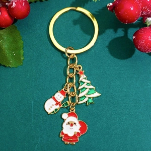 Christmas keychain with Santa Claus, snowman and tree charms on a festive green background