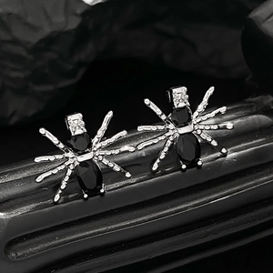 Makroaufnahme von Gothic-Spinne-Ohrringen mit schwarzen Steinen und Silber-Details