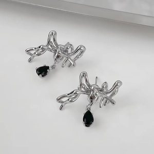 Makroaufnahme von silbernen Spinne-Ohrringen mit schwarzen Tropfen-Strasssteinen im Gothic-Stil