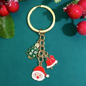 Detail of Christmas keychain with festive pendants featuring Santa and a tree on green background