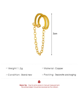 Detail einer goldenen Earcuff mit hängender Kette und Zirkonia auf weißem Hintergrund