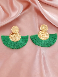 Detalle de pendientes bohemios de aleación dorada con borlas de seda verde en forma de abanico