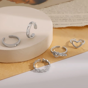 Detailed close-up of a 5-piece vintage silver heart ring set on an aesthetic display